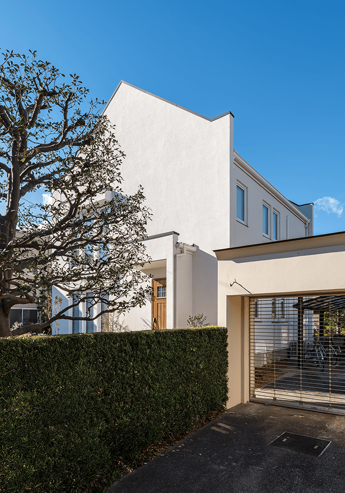 シンプルな白い塗り壁に陰影が映えるモダンな外観-2